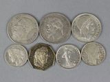 six different british coins are arranged in a row on a white surface