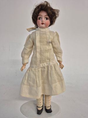 an old fashioned doll with a white dress and black shoes