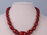 a close up of a red beaded necklace on a mannequin