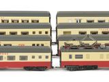 two model trains sitting side by side on a white surface