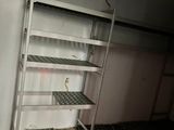 a metal shelf in the middle of a dirty room