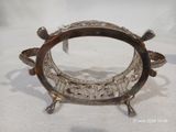une assiette en argent sur laquelle est représentée une tortue, sur un fond blanc