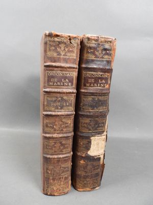 two old books sitting on top of each other on a table