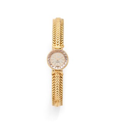 a close up of a gold wrist watch with a chain around it