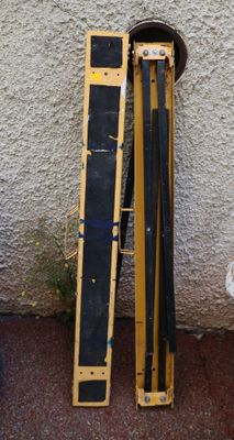 yellow and black skis leaning against a wall next to a fire hydrant
