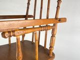 a wooden high chair with wheels on a white background