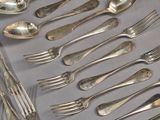 many spoons and forks laid out on a table