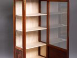 an antique display cabinet with a glass door and shelves in the middle