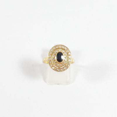 une image représentant une bague en or sertie d'une pierre noire entourée de diamants blancs