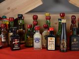 many bottles of alcohol on a table with a red table cloth