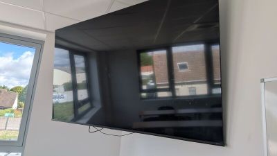 un téléviseur à écran plat fixé au mur d'une pièce