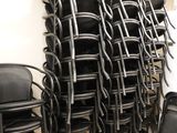rows of black chairs stacked on top of each other in a room