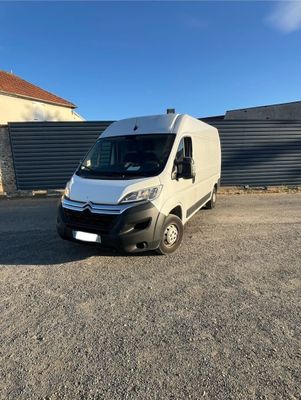 une camionnette blanche garée sur un parking à côté d'un bâtiment