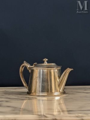 une théière en argent posée sur une table en marbre