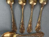 four spoons and a spoon rest on a blue surface