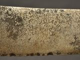an old knife with rust on it sitting on top of a table