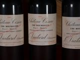 three bottles of red wine are lined up on a table