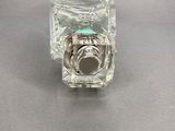 a clear glass object with a silver ring on it