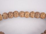 a close up of a wooden beaded necklace on a white surface