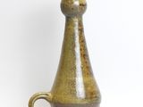 a brown vase that is sitting on a white surface