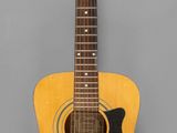 un gros plan d'une guitare acoustique sur fond gris