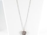 un collier avec un mannequin blanc orné d'un pendentif en forme de cœur