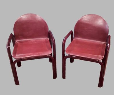 pair of red leather chairs with arms and legs