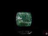 a close up of a green emerald stone on a black surface