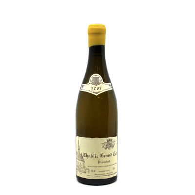 the bottle of white wine is sitting on a white surface