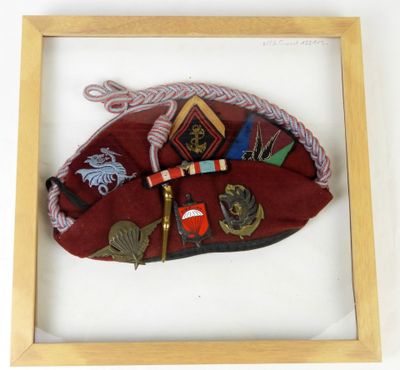 une photo encadrée représentant un chapeau rouge orné de nombreux éléments divers