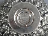 a close up of a silver vase on a table