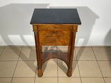 a small wooden table with a black top on a tiled floor