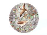 deux oiseaux posés sur une assiette garnie de feuilles