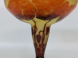an orange and yellow glass vase sitting on top of a white table