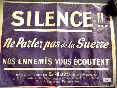 une pancarte violette sur laquelle est inscrit « silence » sur le côté d'un immeuble