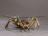 a glass table with a gold spider on it