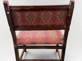 an old wooden chair with a colorful upholstered seat on a white background