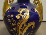 un vase bleu et doré posé sur un sol carrelé