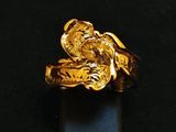 an image of a gold ring on a black surface