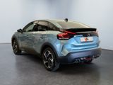 the rear end of a blue car parked in a showroom