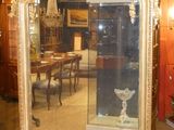 un grand miroir au milieu d'une pièce où se trouvent une table et des chaises