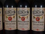 several bottles of red wine are lined up on a shelf