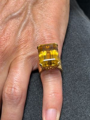 la main d'une femme à laquelle est passée une bague jaune