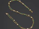 a gold and green necklace with pearls