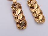 pair of gold tone earrings on white background with white background