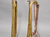 pair of brass trumpets with tassels on a gray background