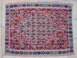 a pink rug on a tiled floor with a white tile floor