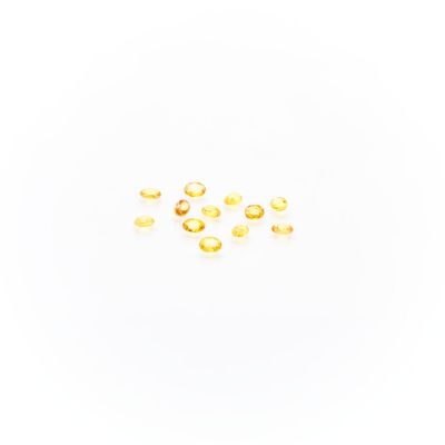a close up of a group of gold rings on a white surface