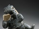 figurine of a bear with a wooden spoon in its mouth
