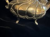 une théière en argent posée sur un tissu noir